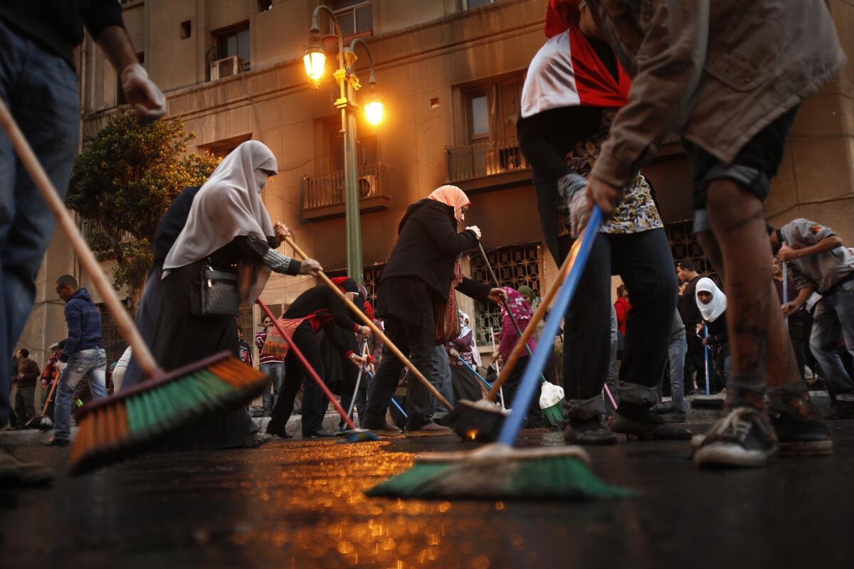 Volunteers sweep the streets around Tahrir Square after an 18-day occupation ended in February 2011.