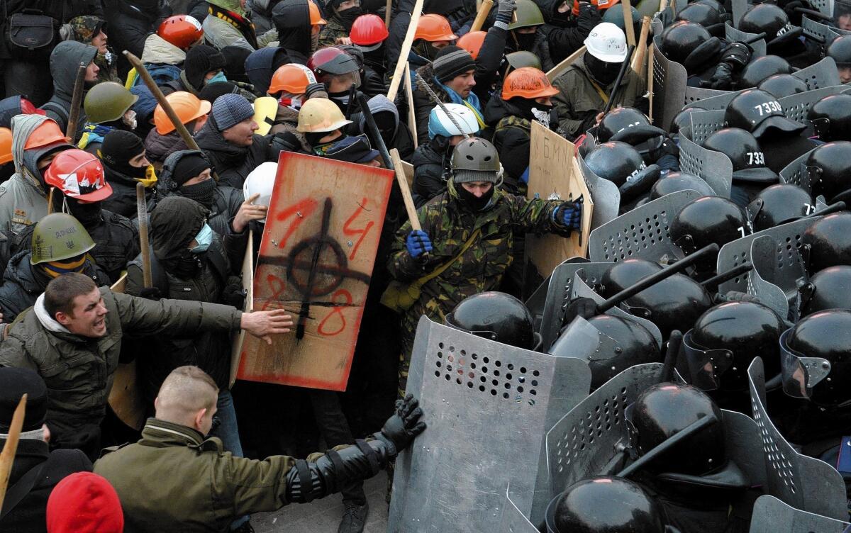 Protesters clash with riot police in Kiev, Ukraine. Most of the demonstrators are wearing construction helmets, defying a provision of the nation's new laws aimed at curbing protests.