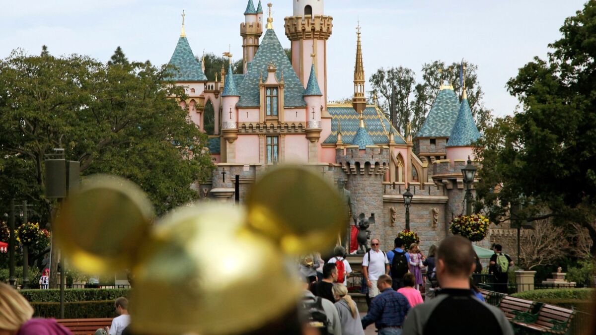 Visitors walk toward Sleeping Beauty's Castle at Disneyland in 2015.