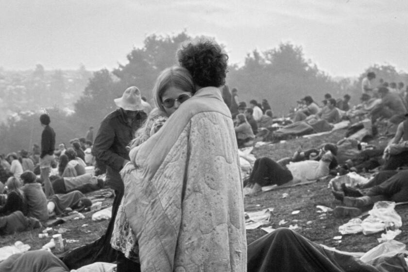 A couple embraces at the Woodstock music festival.