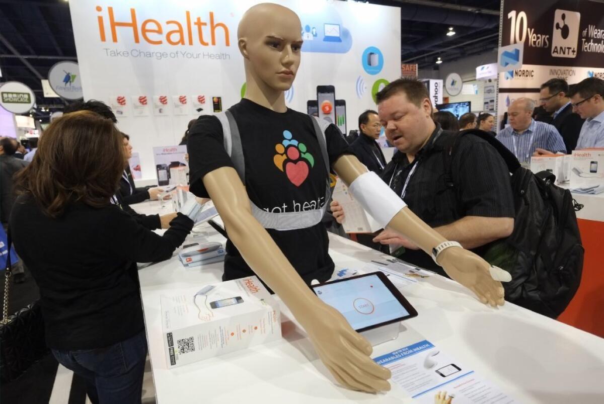CES attendees check out wireless iHealth blood pressure monitors, something that AT&T executives may need after attacks from rival T-Mobile.