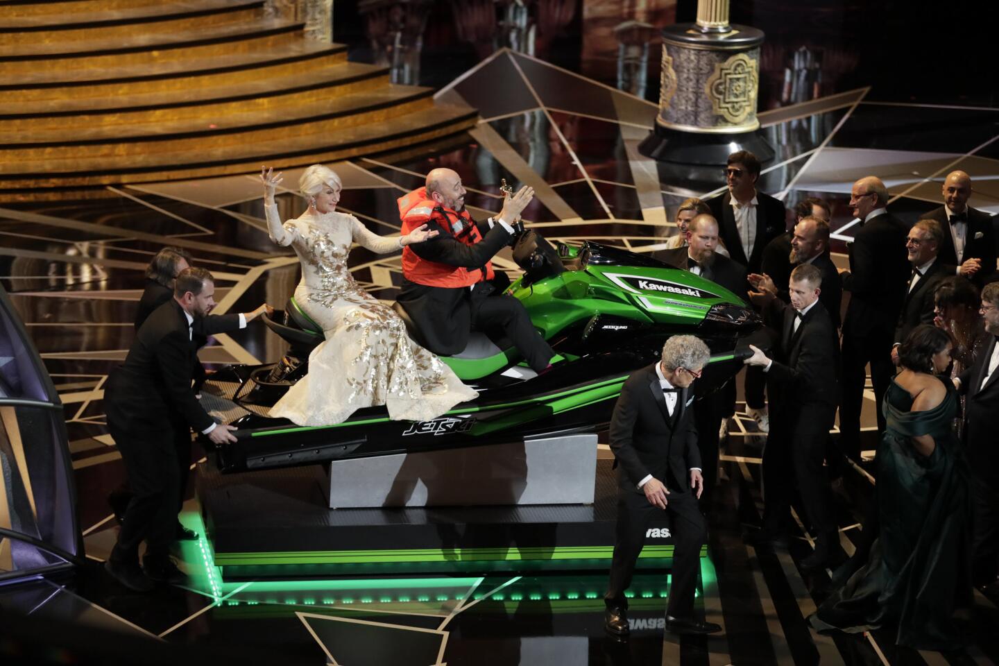 Costume designer Mark Bridges ("Phantom Thread"), with Helen Mirren in tow, rides onstage with the jet ski he won for having the fastest winners' speech during the telecast of the 90th Academy Awards.