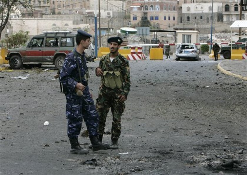 Two Yemeni soldier guard by damaged vehicles in front of the main entrance of the US Embassy in the capital San'a, Yemen Thursday, Sept. 18, 2008. Militants linked to al-Qaida launched a brazen attack against the U.S. Embassy in the Yemeni capital Wednesday, firing automatic weapons and setting off grenades and a car bomb in a furious fusillade that failed to breach the walls but killed 16 people, including a newly wed New York woman. (AP Photo/Hussein Malla)