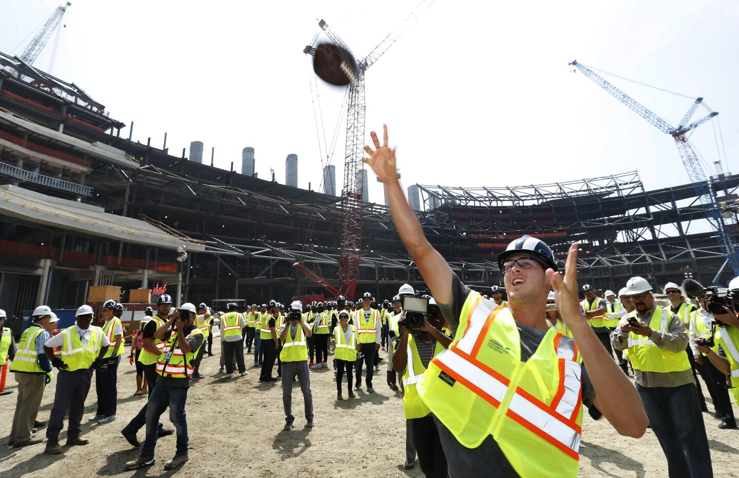 Rams quarterback Jared Goff tosses a football up to construction workers in one of the decks above, during a tour of Los Angeles Stadium at Hollywood Park in Inglewood, the future home of the Rams. Instead of practice on the final day of minicamp, the Rams players and coaches boarded buses and headed to the stadium under construction in Inglewood.