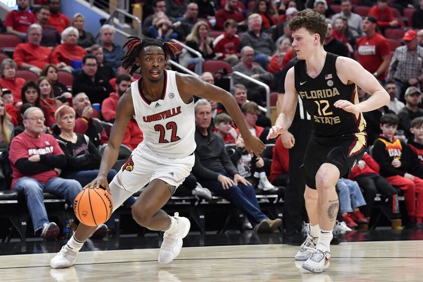 Louisville forward Kamari Lands (22) drives past Florida State guard Tom House (12) during the second half of an NCAA college basketball game in Louisville, Ky., Saturday, Feb. 4, 2023. (AP Photo/Timothy D. Easley)