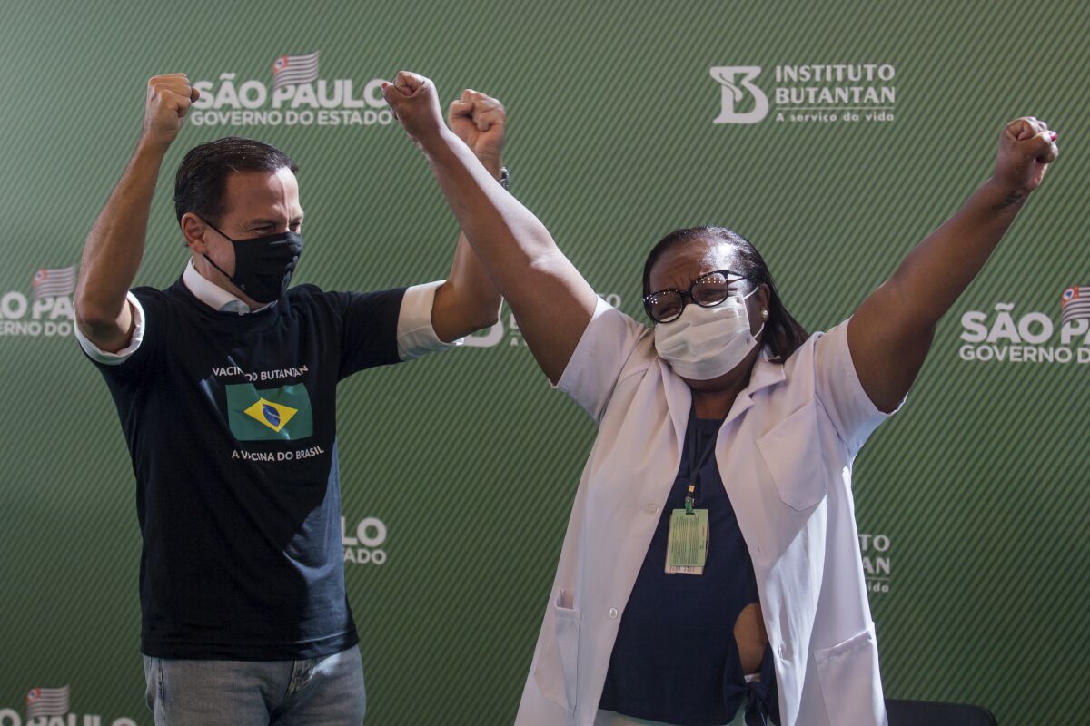 Nurse Monica Calazans and Gov. Joao Doria of Brazil's Sao Paulo state celebrate after she got her COVID-19 shot Sunday.