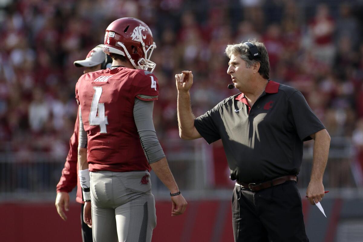 Washington State Coach Mike Leach, right, and quarterback Luke Falk (4) quietly have led the Cougars to a 6-3 record.
