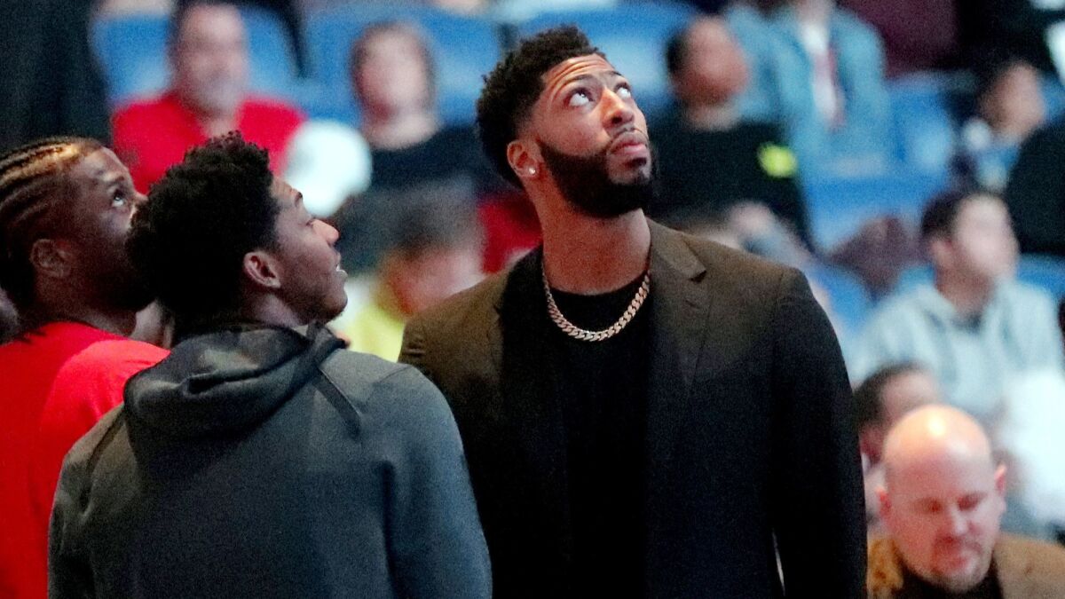 Pelicans forward Anthony Davis watches a video tribute to Chuck Edwards, the late Pelicans announcer, during a timeout in the first half of a game against the Indiana Pacers on Monday in New Orleans.