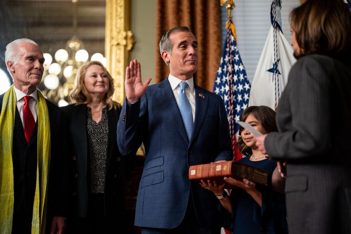 Eric Garcetti raises his right hand as he takes the oath of office 