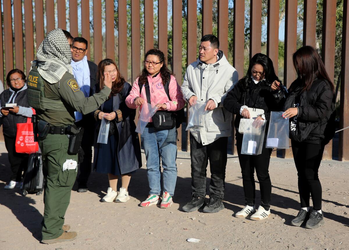 Cinco ciudadanos chinos, a la derecha, solicitan asilo en la frontera entre México y Estados Unidos