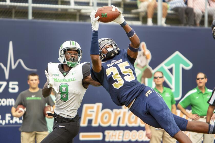 Florida International University cornerback Rishard Dames (35) intercepts the pass intended for Marshall wide receiver Tyre Brady (8) during the second quarter of an NCAA college football game, Saturday, Nov. 24, 2018, in in Miami. (Daniel A. Varela/Miami Herald via AP)