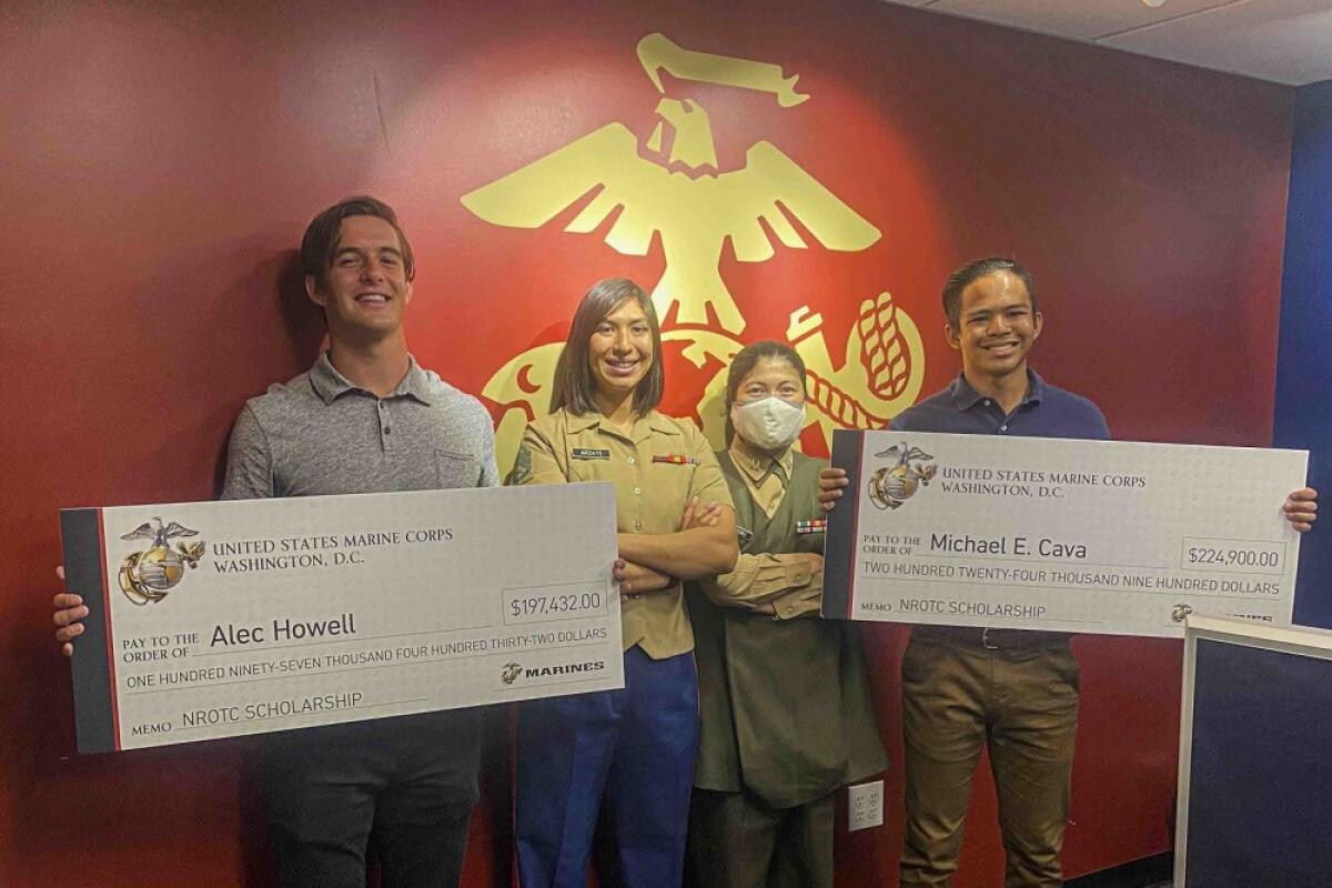 USMC Staff Sgt. Maria Arzate and Capt. Katie Sliwoski present Alec Howell and Michael Cava with their scholarships.
