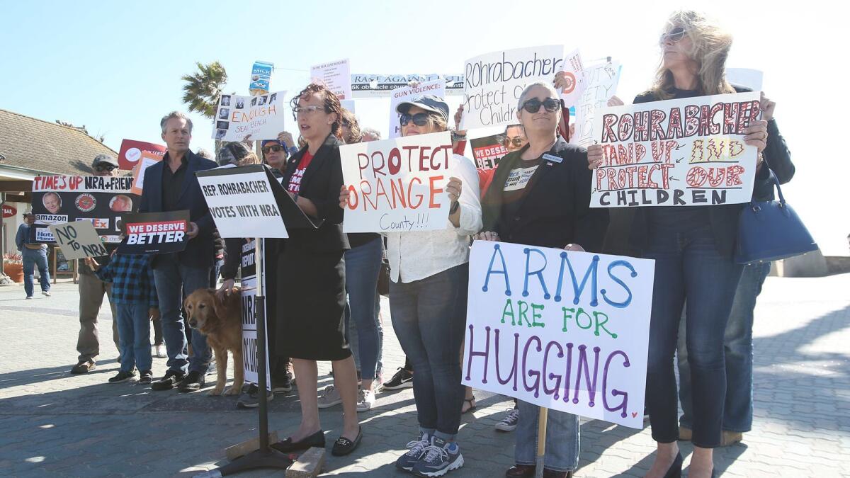 A group of Orange County students, educators and their supporters gather Thursday in Huntington Beach to oppose Rep. Dana Rohrabacher’s gun-rights positions also advocated by the National Rifle Assn.