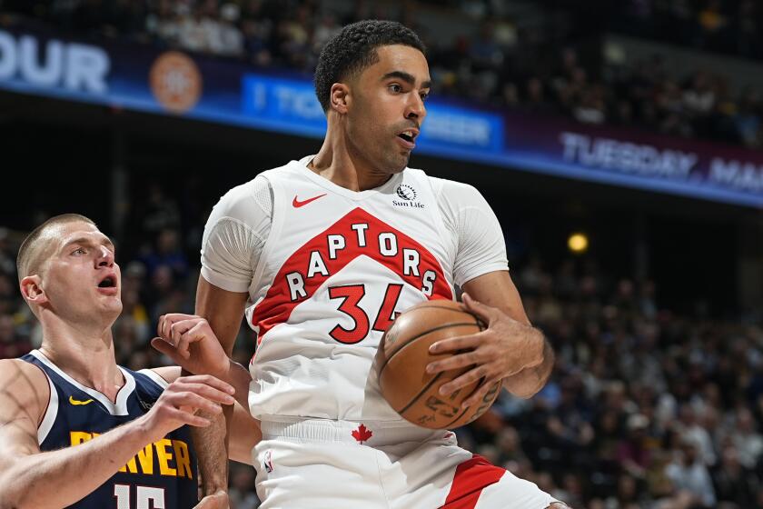 Jontay Porter, derecha, pívot de los Raptors de Toronto, descuelga un rebote frente.