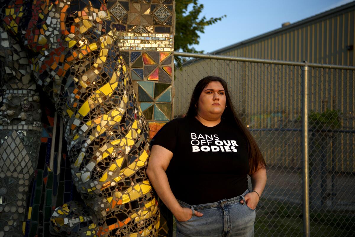 Olivia Julianna poses in a shirt that says "Bans off our bodies"