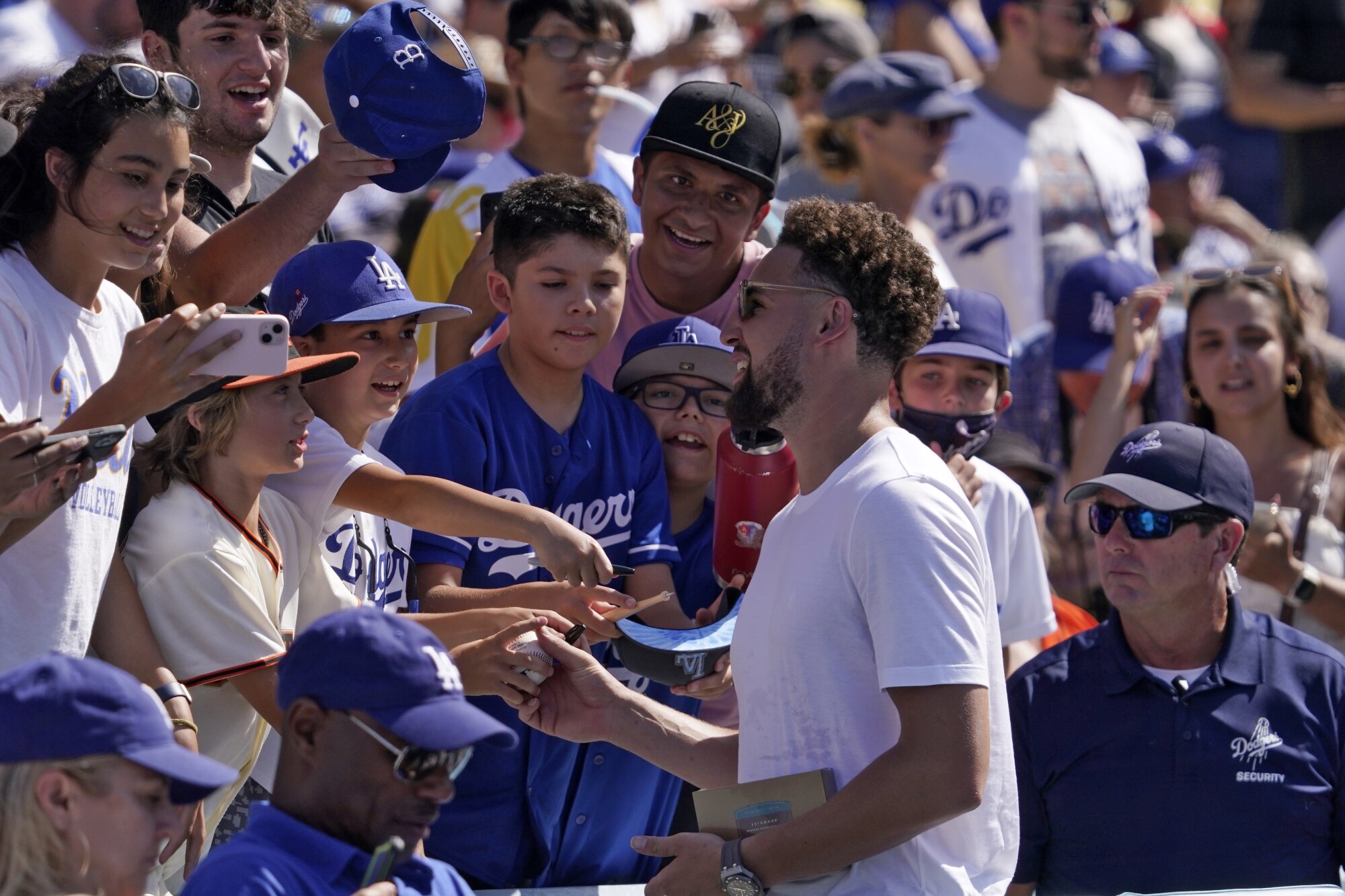 La star dei Golden State Warriors Klay Thompson firma autografi per i fan mentre guarda i Dodgers giocare ai San Francisco Giants