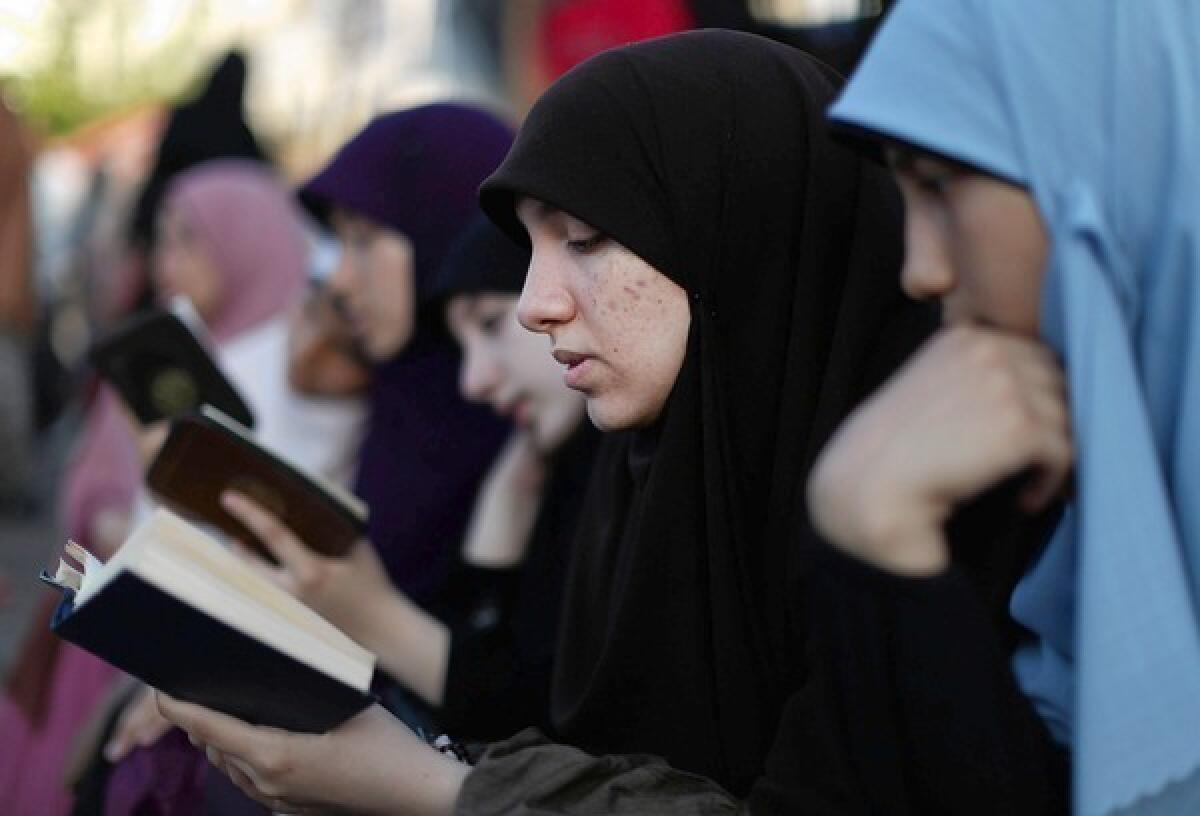 Egyptian supporters of the Muslim Brotherhood read the Koran, Islam's holy book, outside Cairo's Rabaa al Adawiya mosque.