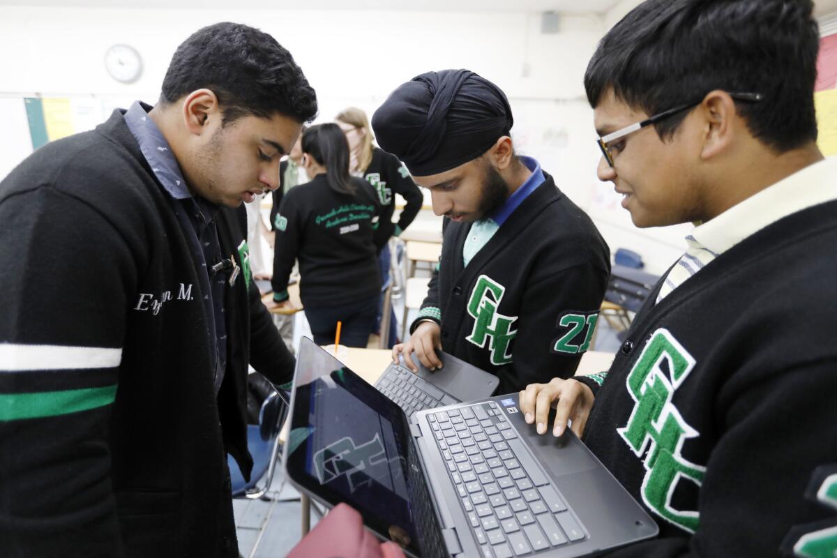 From left, Ezhan Mirza, 17, Jasdeep Sidhu, 15, and Dwaipayan Chanda, 15, look up the scores of the alternates on their team who participated in the online version of the U.S. Academic Decathlon in Bloomington, Minn., recently.