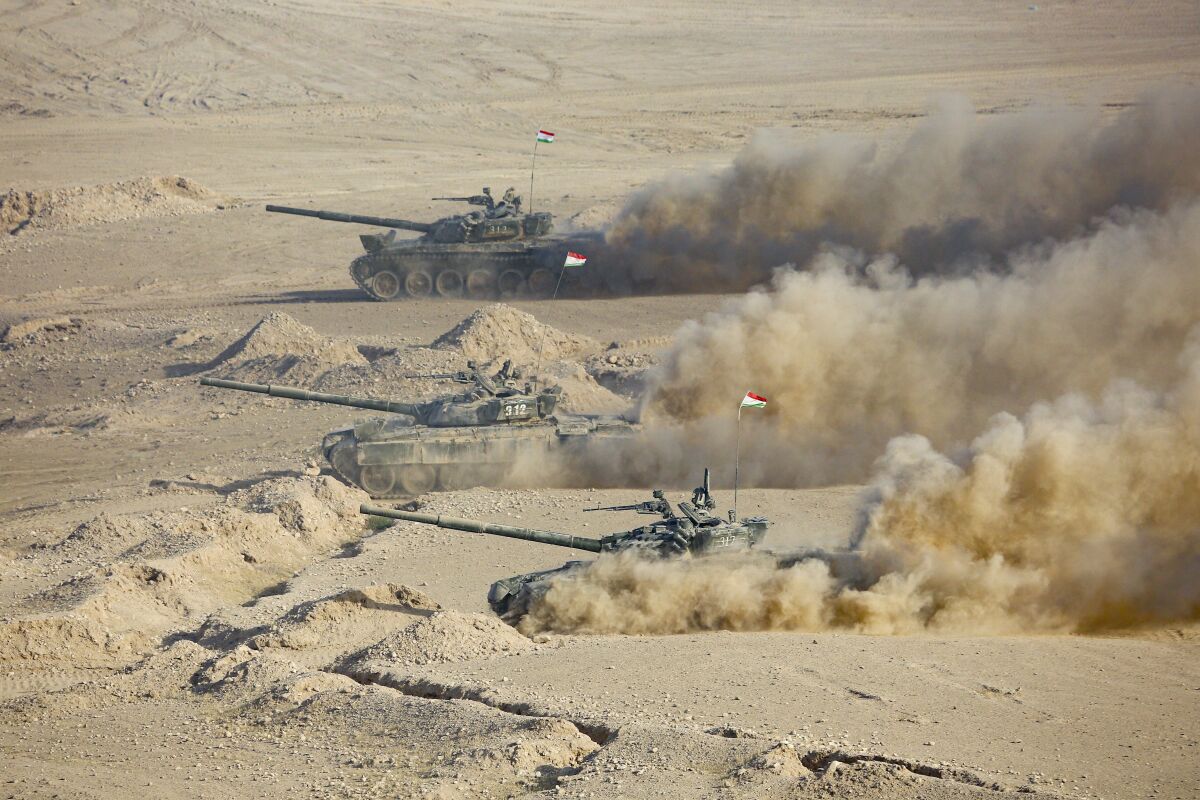 Tajikistan's tanks roll during a joint military drills by Russia and Uzbekistan at Harb-Maidon firing range about 20 kilometers (about 12 miles) north of the Tajik border with Afghanistan, in Tajikistan, Tuesday, Aug. 10, 2021. The troops from Russia, Tajikistan and Uzbekistan on Tuesday wrapped up their drills intended to simulate a joint response to potential security threats coming from Afghanistan. The war games that began last week involved 2,500 Russian, Tajik and Uzbek troops and about 500 military vehicles. (AP Photo/Didor Sadulloev)