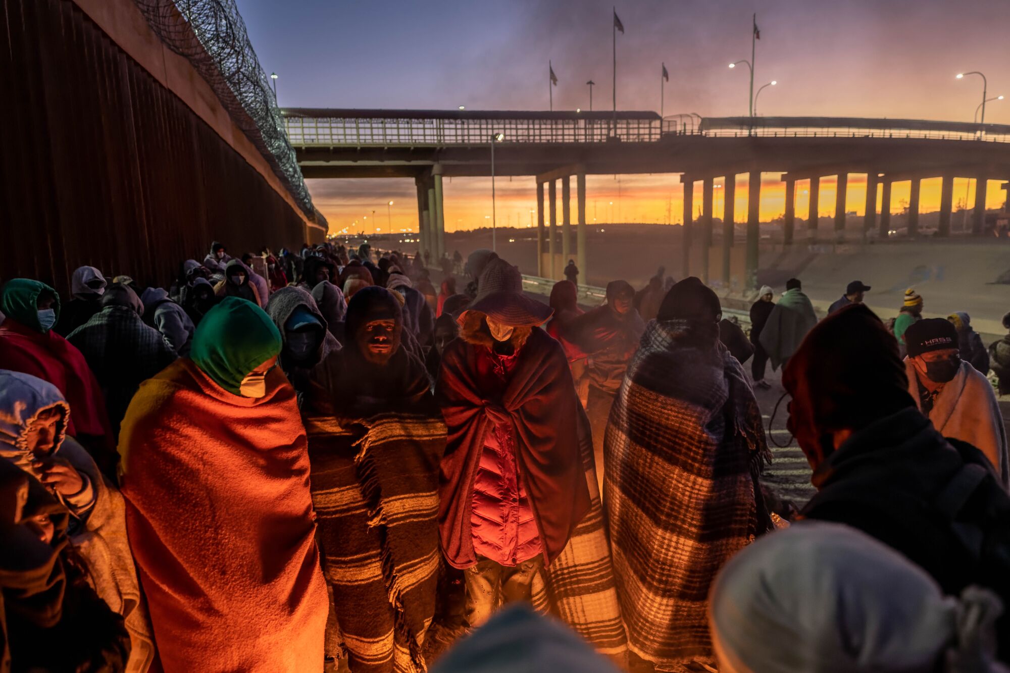   Battaniyelere sarılı göçmenler ateşin etrafında toplandı 