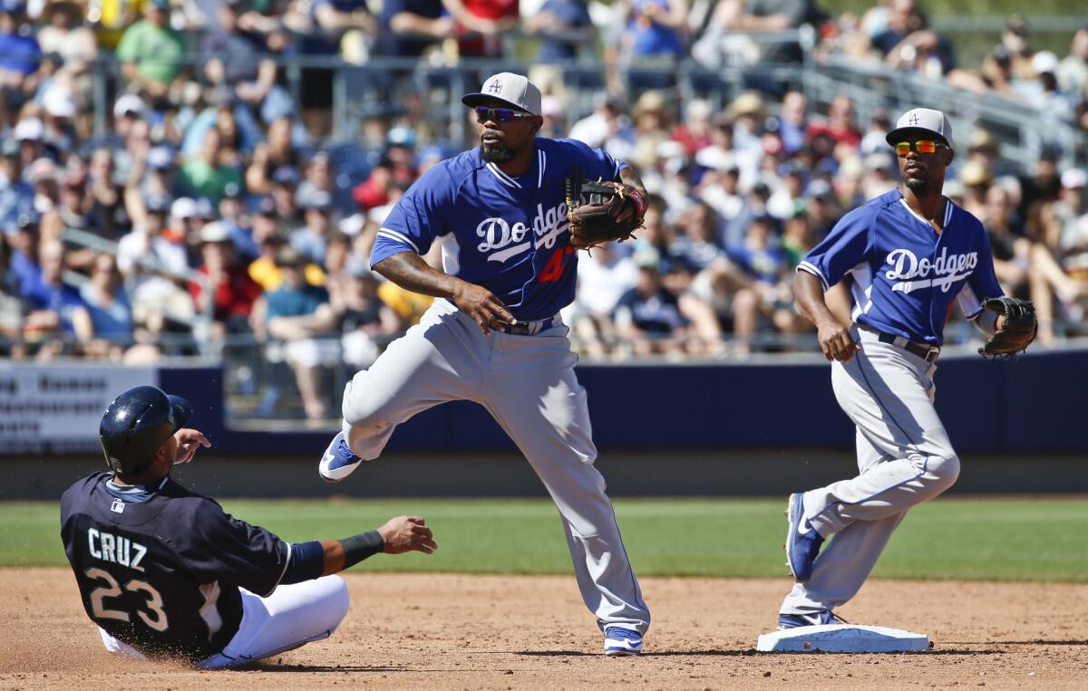 Howie Kendrick makes a relays throw to first base from shortstop Jimmy Rollins as Seattle's Nelson Cruz slides in to second base during a game March 15.