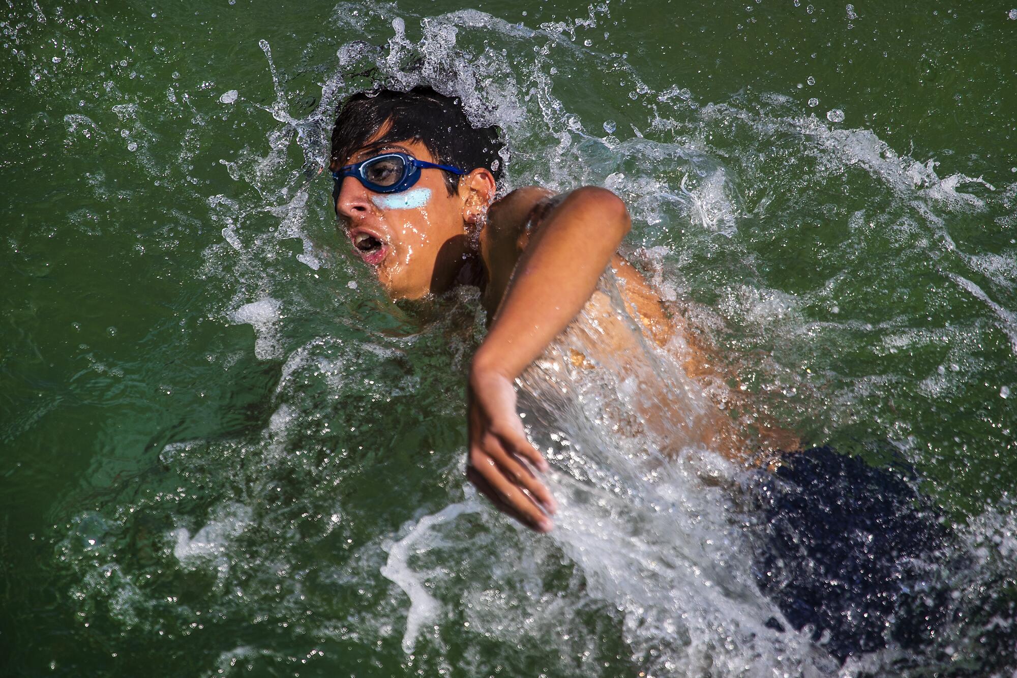 A Los Angeles County junior lifeguard swims in the water at Hermosa Beach Pier.