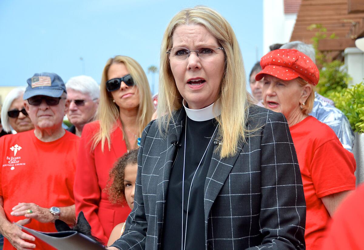The Rev. Canon Cindy Evans Voorhees emphasizes the importance of St. James The Great Episcopal Church remaining intact during a press conference in front of the church held Thursday.