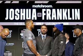 El boxeador Anthony Joshua (izquierda) en cara a su próximo rival Jermaine Franklin, el miércoles 29 de marzo de 2023, en Londres. En medio aparece el promotor Eddie Hearn (Zac Goodwin/PA via AP)