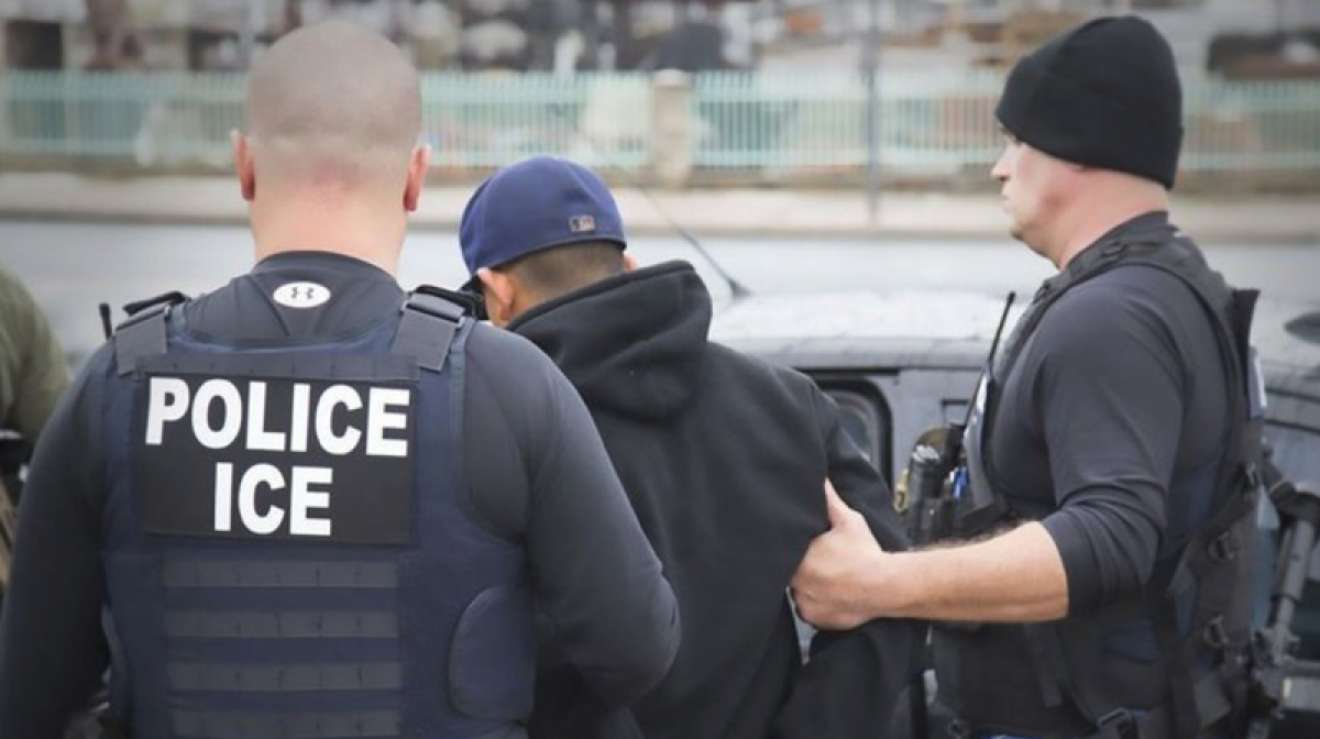 U.S. Immigration and Customs Enforcement officers detain a man