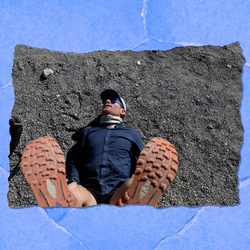 A man lies on the ground with his tennis-shoe-clad fit in the air.