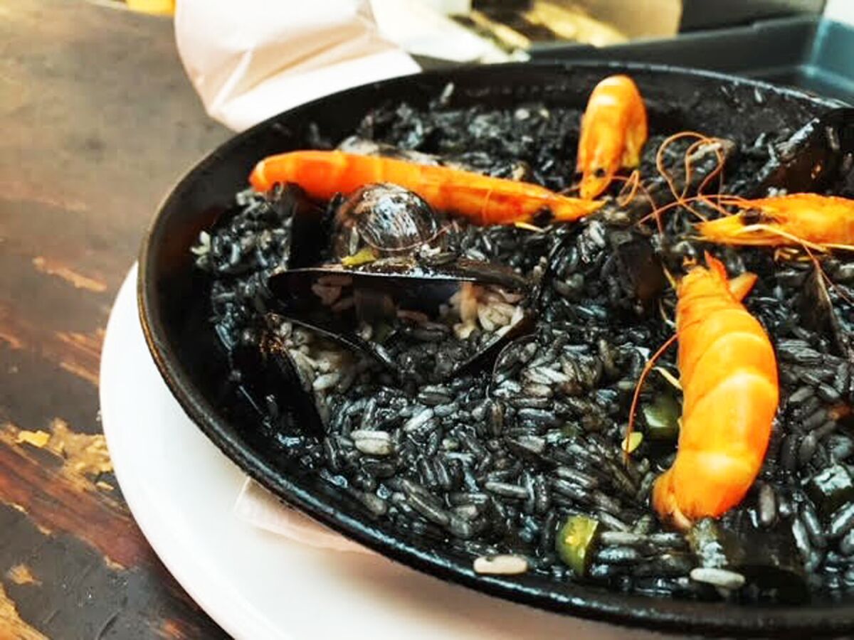 Arroz negro con sepia (aka black paella — rice with calamaris cooked in a paella pan with a squid ink based saffron broth).