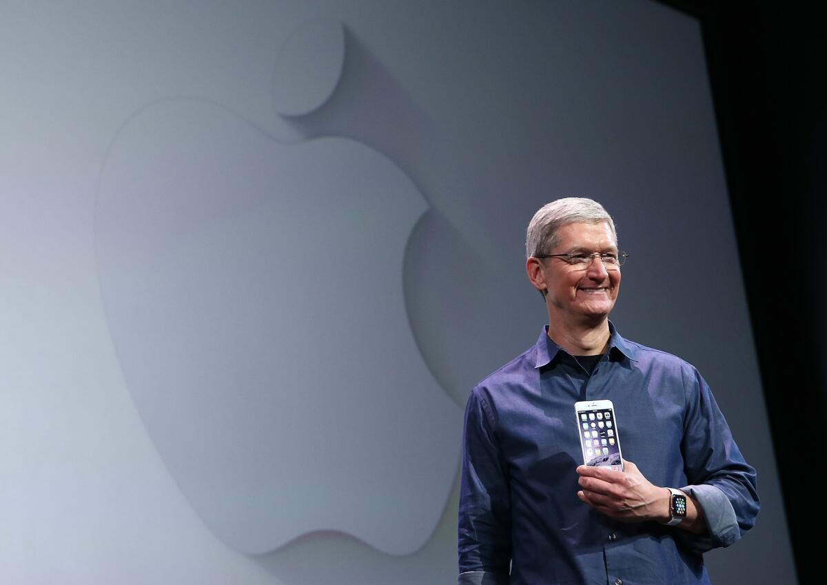 Apple CEO Tim Cook shows off the new iPhone 6 and the Apple Watch during an Apple event.