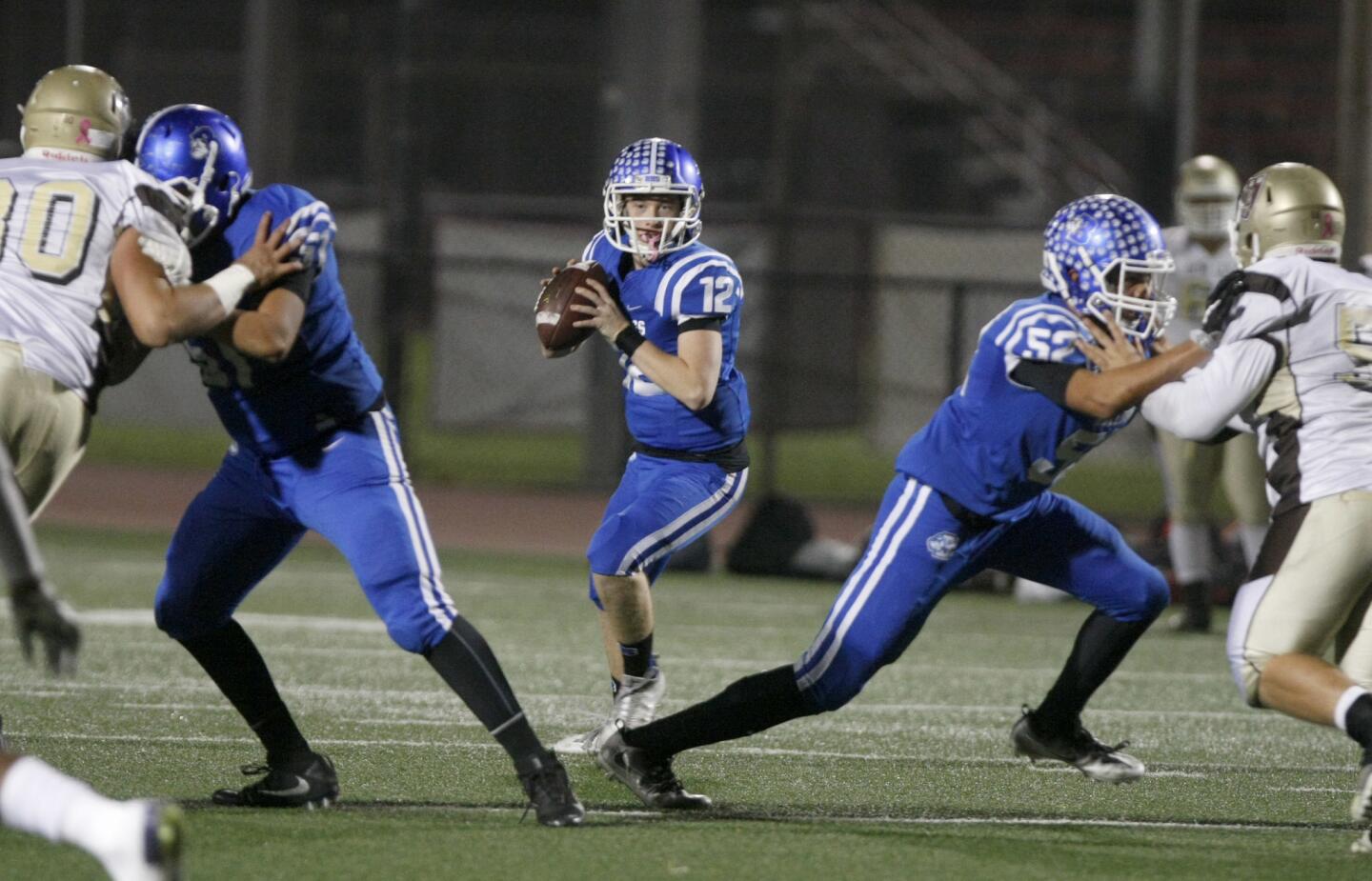 Burbank High School football player #12 quarterback Guy Gibbs looks to pass against the Don Lugo High School quarterback in CIF Southern Section Div. VIII semifinal game at home in Burbank on Friday, Nov. 25, 2016.