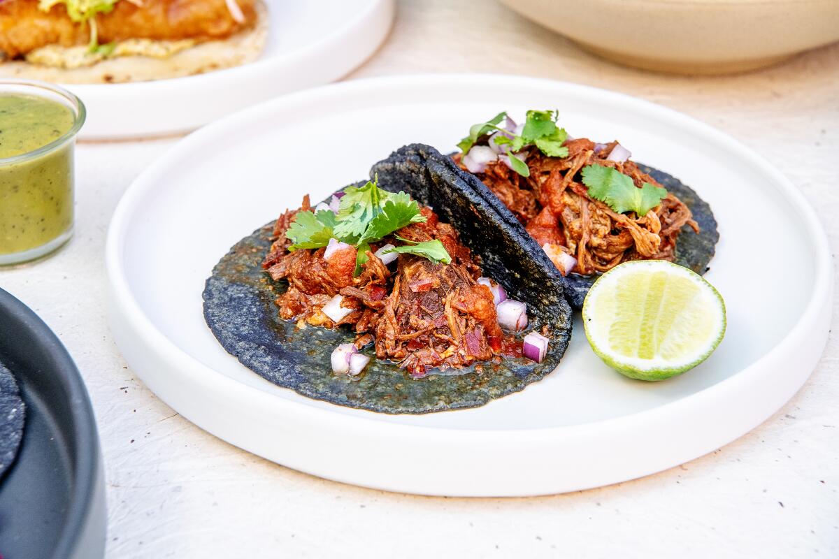 Birria tacos on a plate with lime