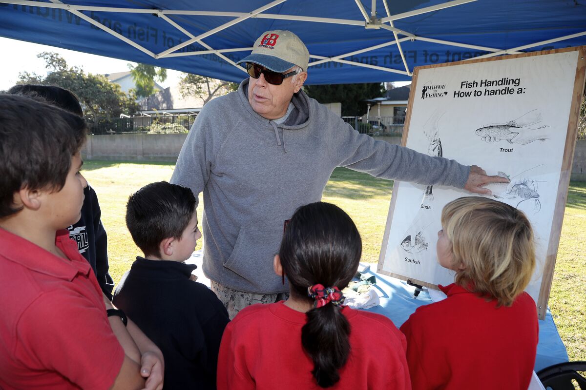 Huntington Beach Fishing and Recreation Club member Bill Saksa explains how to handle a fish at Carr Park.