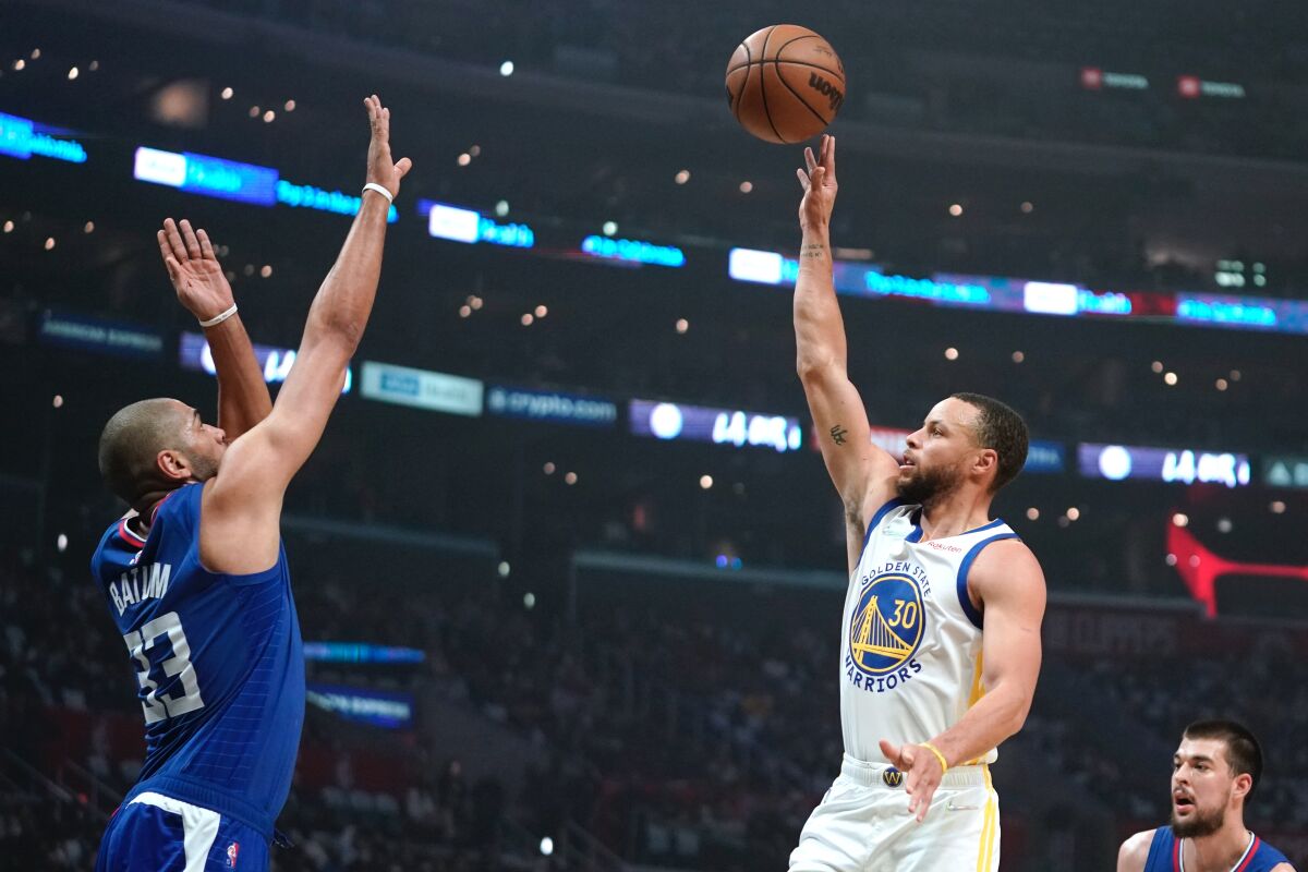 Golden State Warriors guard Stephen Curry shoots as Los Angeles Clippers forward Nicolas Batum defends during the first half of an NBA basketball game Monday, Feb. 14, 2022, in Los Angeles. (AP Photo/Mark J. Terrill)