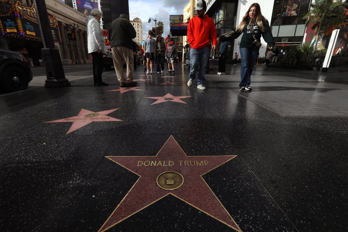 Visitors walk towards Donald Trump's star on the Hollywood Walk of Fame in Hollywood