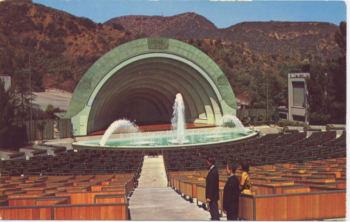 Two men and a woman stand in an aisle at the Hollywood Bowl.
