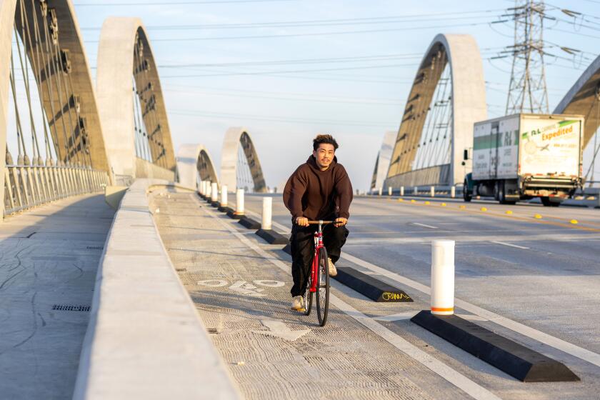 LOS ANGELES, CA - JANUARY 15, 2024: A cyclist descends down the Sixth Street Viaduct, aka the Sixth Street Bridge, which connects the Arts District and the Boyle Heights neighborhoods in downtown Los Angeles on Monday, Jan. 15, 2024. (Silvia Razgova / For The Times)