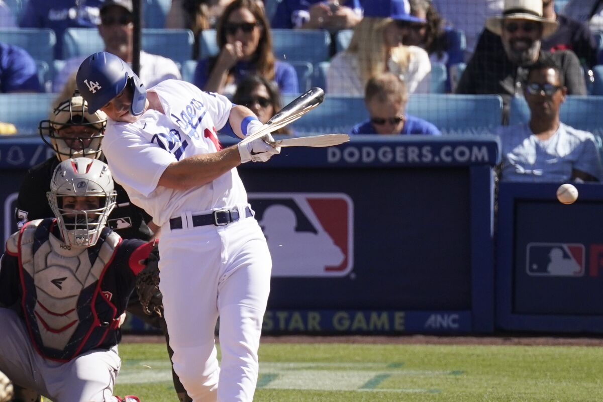 Will Smith hits a broken-bat single for the Dodgers against the Guardians on Saturday.