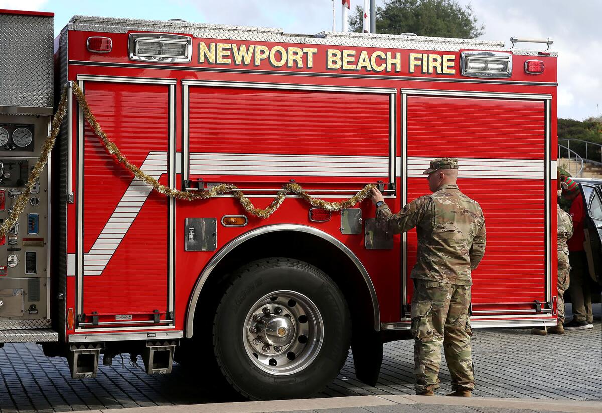 Members of the Army aviation battalion from Joint Forces Training Base Los Alamitos decorate a fire engine. 