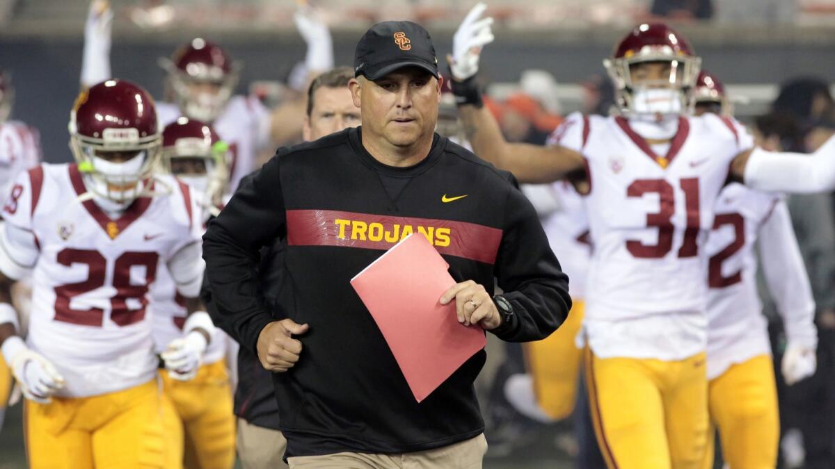 USC football coach Clay Helton leads the Trojans onto the field before a game against Oregon State in November.