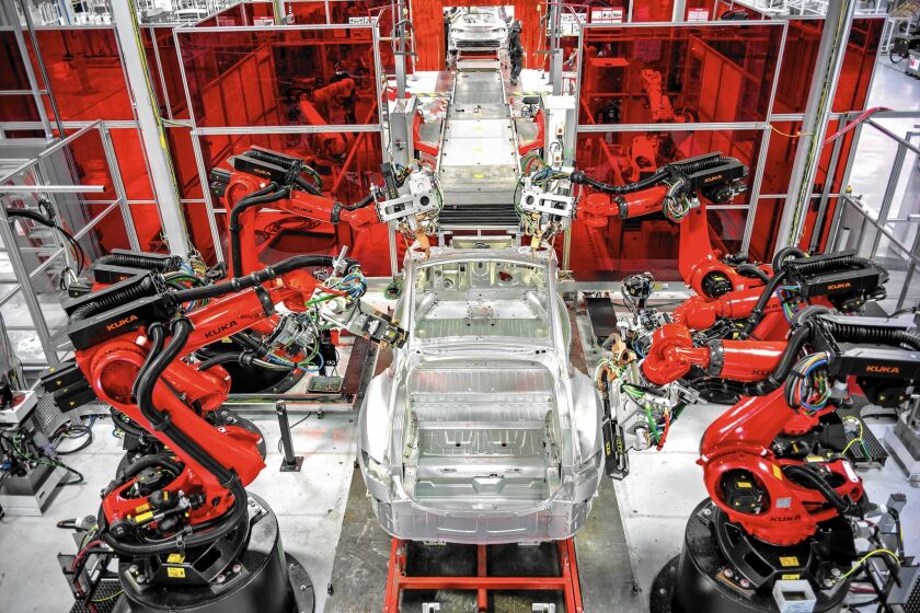 Tesla is spending what Chief Executive Elon Musk called “staggering amounts of money” on gearing up for mass production. Above, robots assemble Model S sedans at the electric car maker’s 5.3-million-square-foot plant in Fremont, Calif.