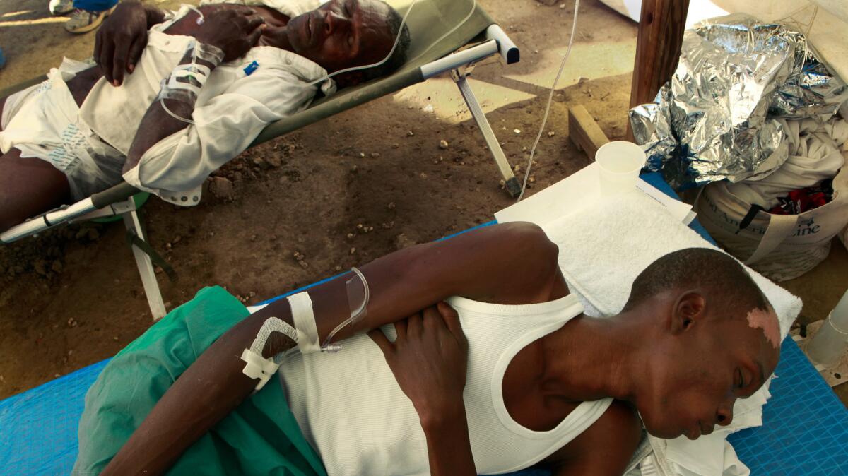 In this 2010 file photo, two men suffering from cholera rest while receiving treatment at an emergency cholera clinic run by Samaritan's Purse outside Cabaret, Haiti.