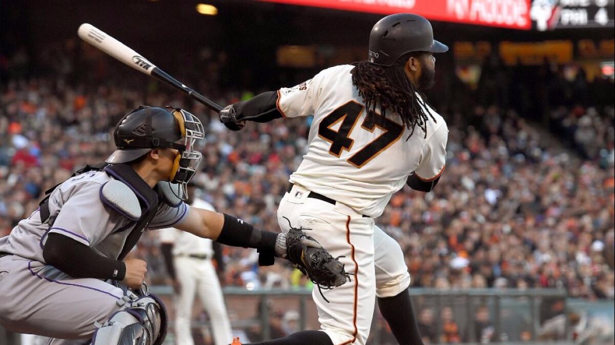 Johnny Cueto gets a base-hit during the bottom of the second inning of a game against the Rockies on July 6.