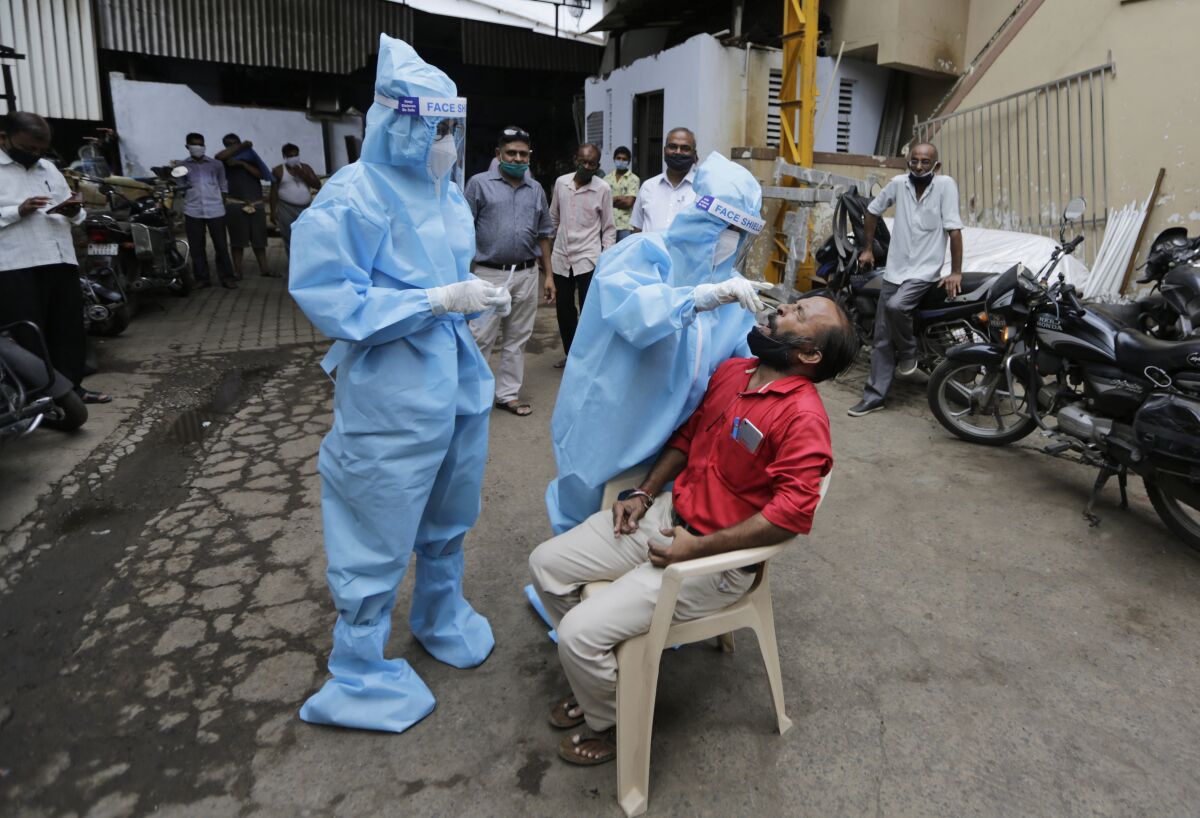 A health worker takes a nasal swab sample to test for COVID-19 in Ahmedabad, India, Friday, Sept. 11, 2020. India's coronavirus cases are now the second-highest in the world and only behind the United States. (AP Photo/Ajit Solanki)