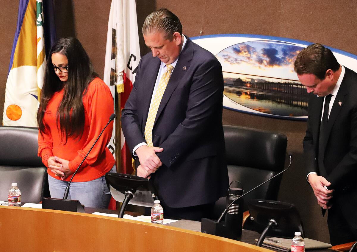 Huntington Beach Mayor Pro Tem Gracey Van Der Mark, left, Mayor Tony Strickland and Councilman Casey McKeon in prayer.