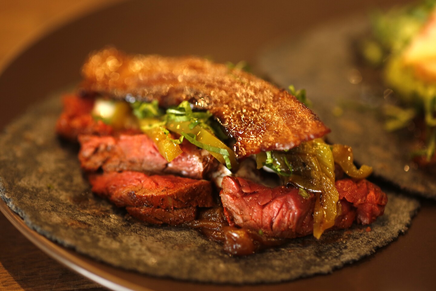 The Arrachera taco is made with hanger steak, roasted chiles, queso and topped with applewood bacon at Taco Maria at the OC Mix at SoCo in Costa Mesa.
