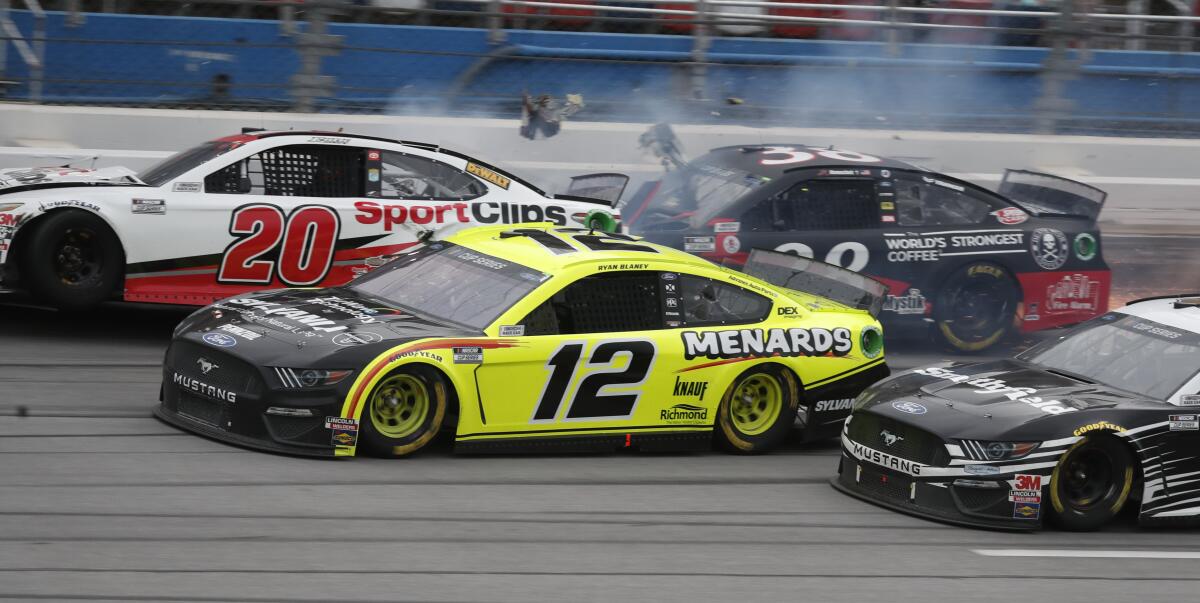 Ryan Blaney approaches the finish line as Erik Jones crashes at the at Talladega Superspeedway in Talladega Ala. on Monday.