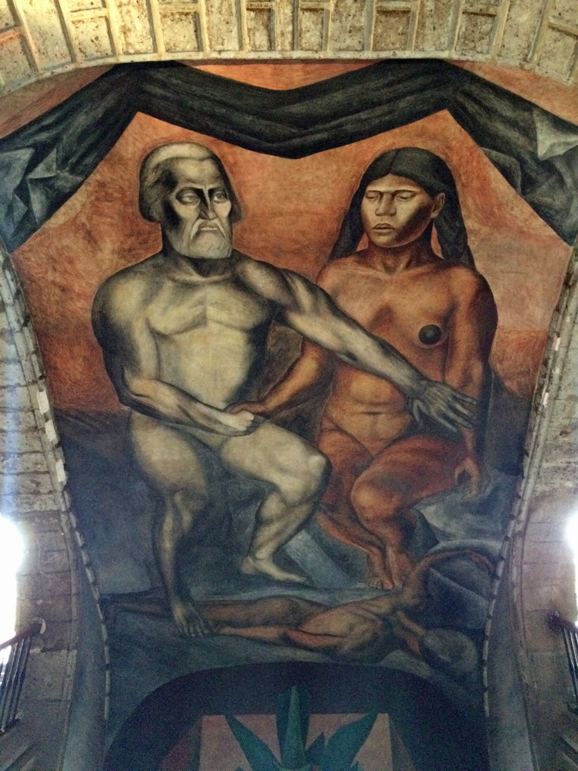 A mural shows a nude Hernán Cortés extending an arm before a nude, seated Malinche, who remains expressionless